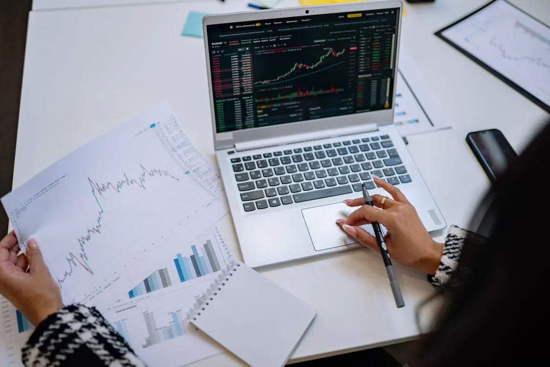 Profesional del área financiera revisando datos y gráficos en un portátil como parte de la automatización financiera.