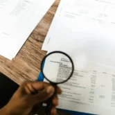 Lupa que resalta la actividad de la cuenta y los detalles de las transacciones en un estado financiero.