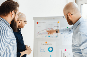  Three finance professionals reviewing charts and financial performance data to support finance automation decisions.