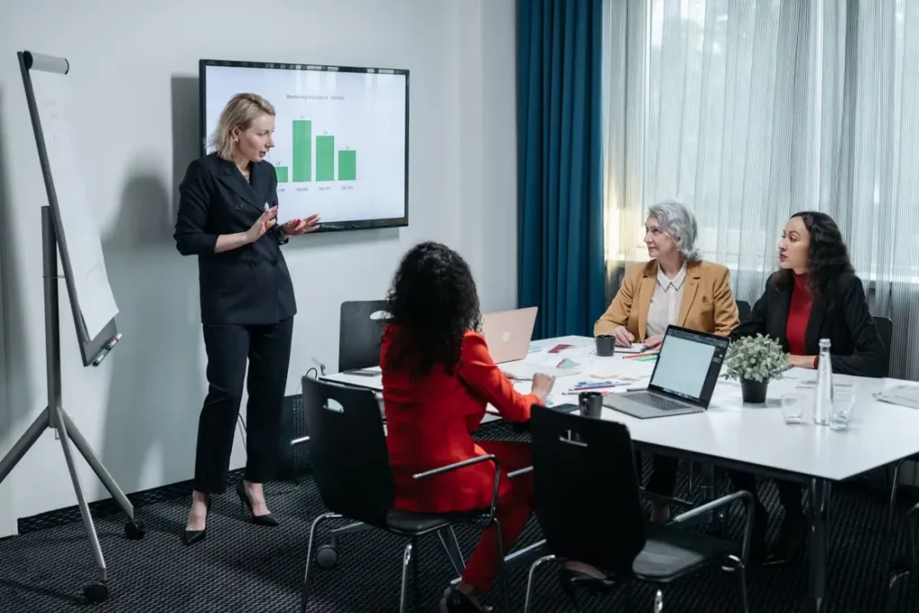 Business team discussing financial performance and reviewing data during a meeting, illustrating the importance of avoiding common OneStream implementation mistakes.