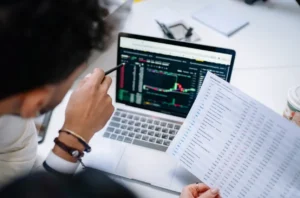 Profesional del área financiera revisando datos e informes financieros en un portátil durante la fase posterior a la implementación de una transformación financiera.