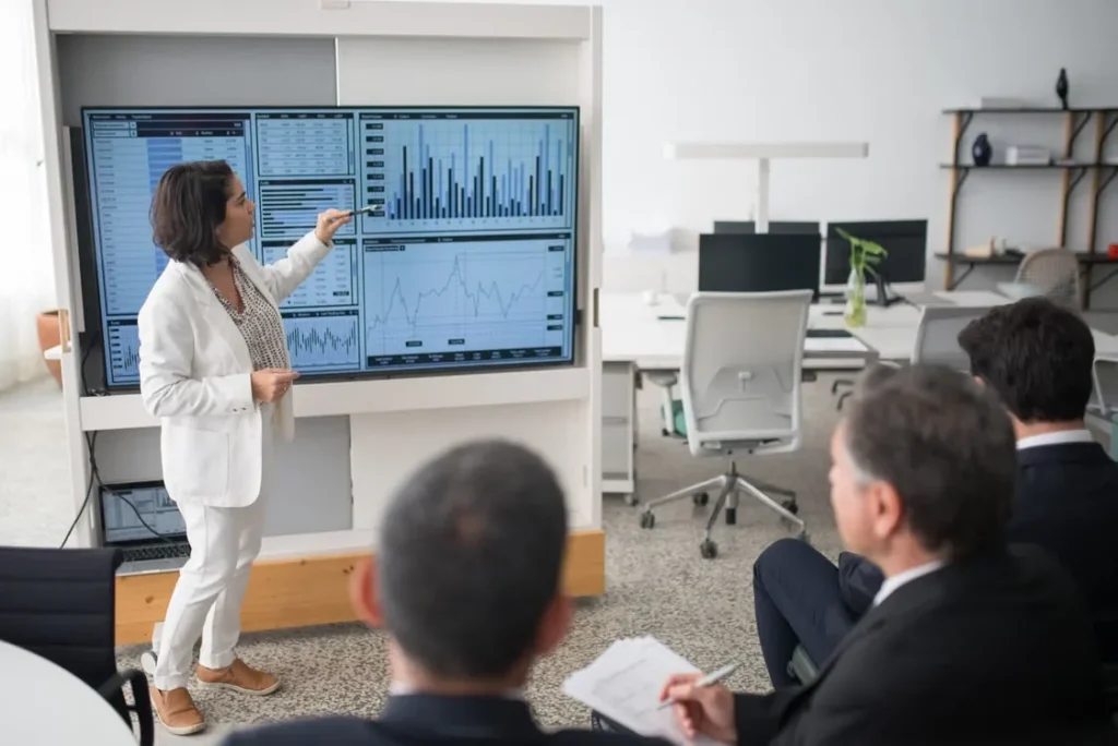 Finance professional presenting financial dashboards and analytics to a business team during a OneStream implementation discussion.